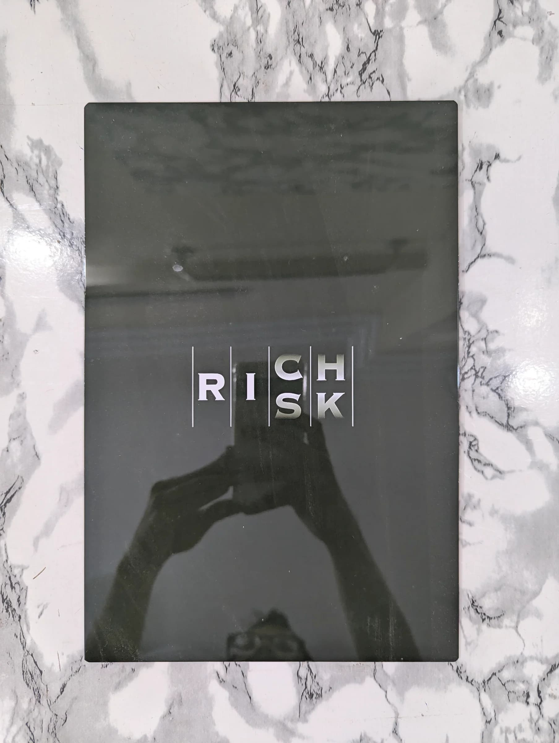Black and white metal poster photograph of a handshake with vertical 'High Risk' typography