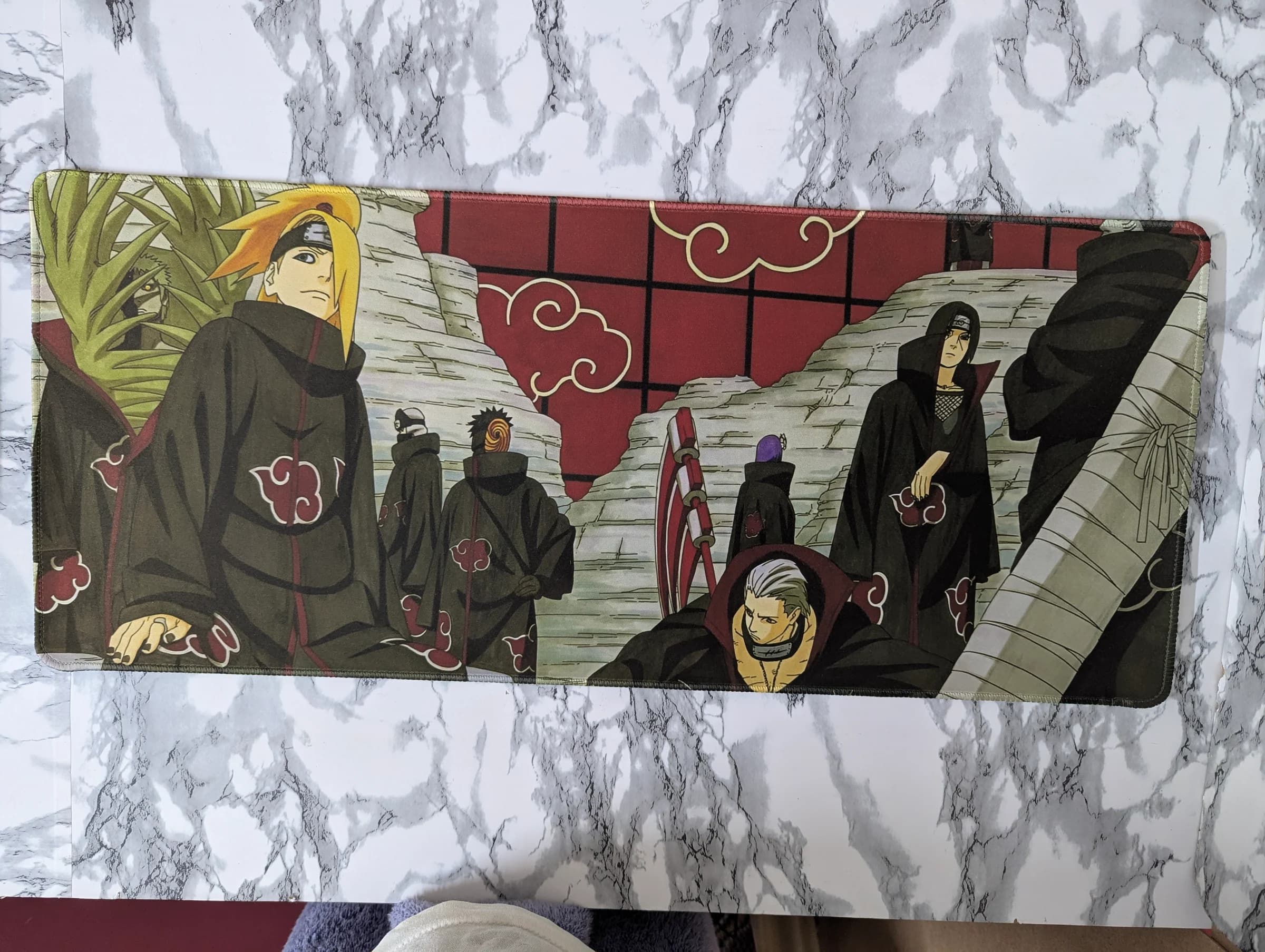 Desk mat illustration of the Akatsuki organization from Naruto walking together in their signature black cloaks with red cloud patterns