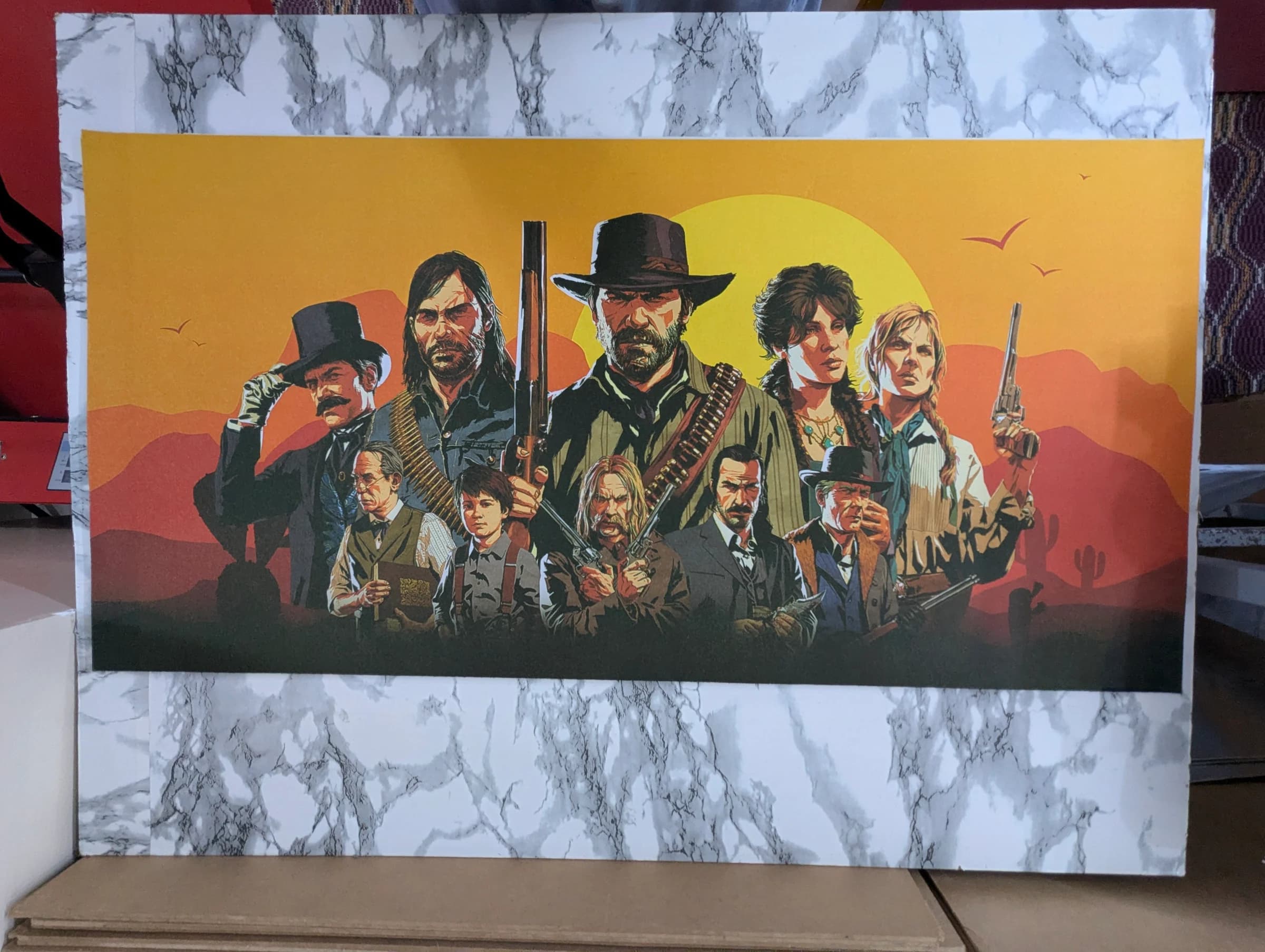 Desk mat illustration of an Old West outlaw gang standing together with pistols, rifles, and ammunition belts against an orange sunset